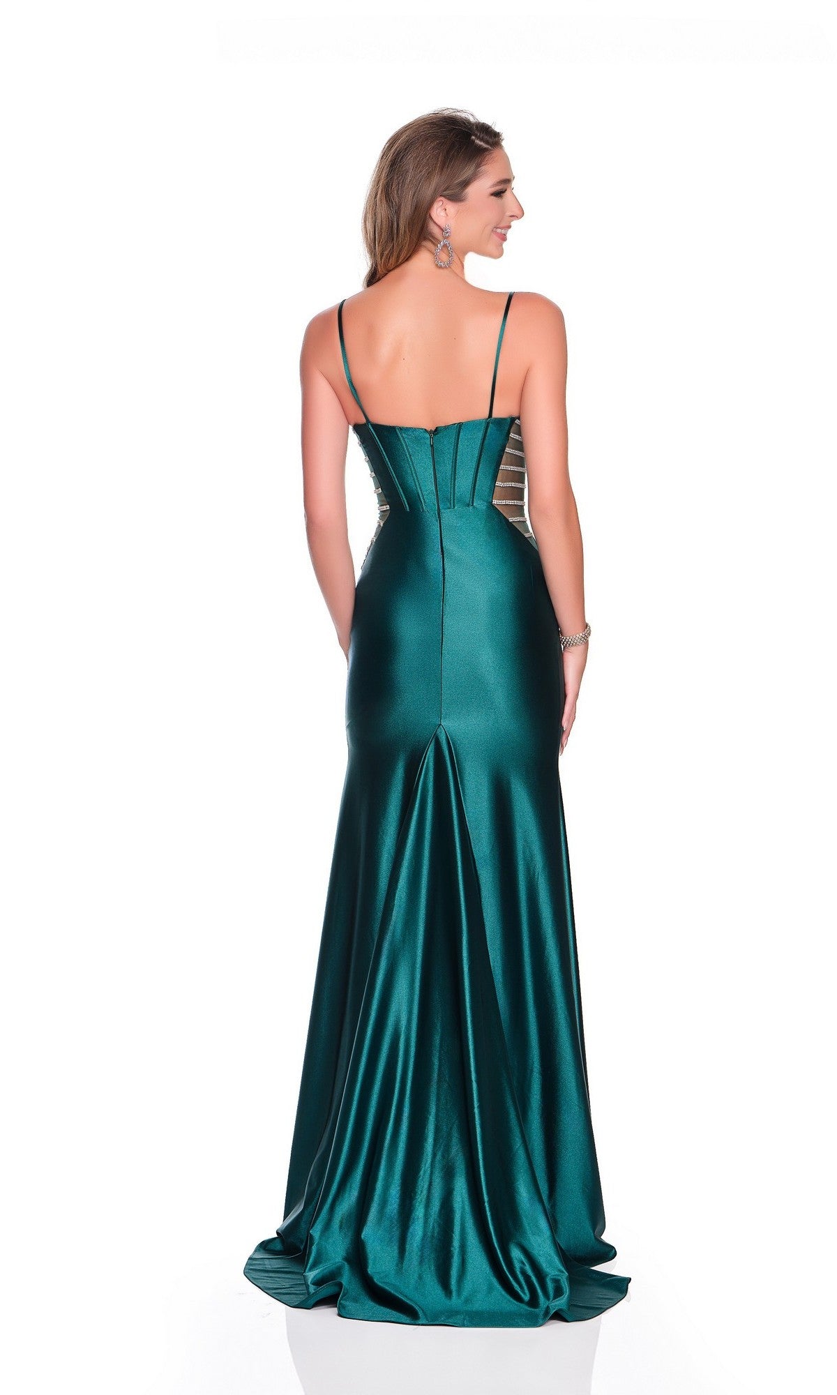 A woman stands with her back to the camera wearing the Long Prom Dress: Dave and Johnny 12574—an emerald satin gown featuring thin straps, a corset bodice, and a flared skirt.